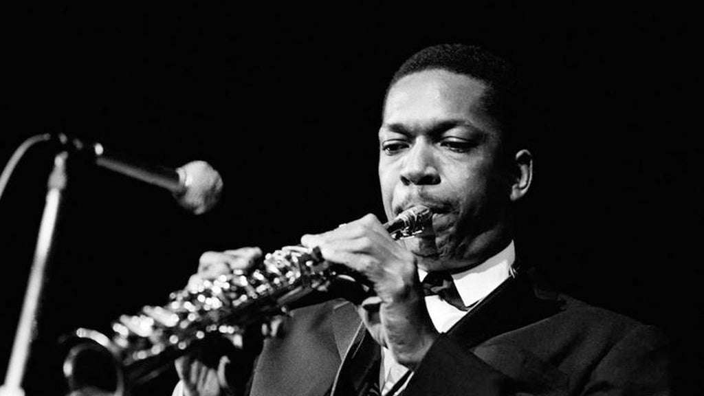 John Coltrane playing the saxophone into a microphone