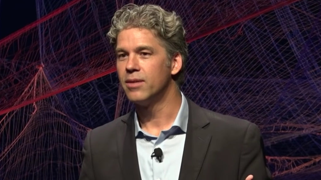 Damien riehl in a suit speaking on stage on ted talk