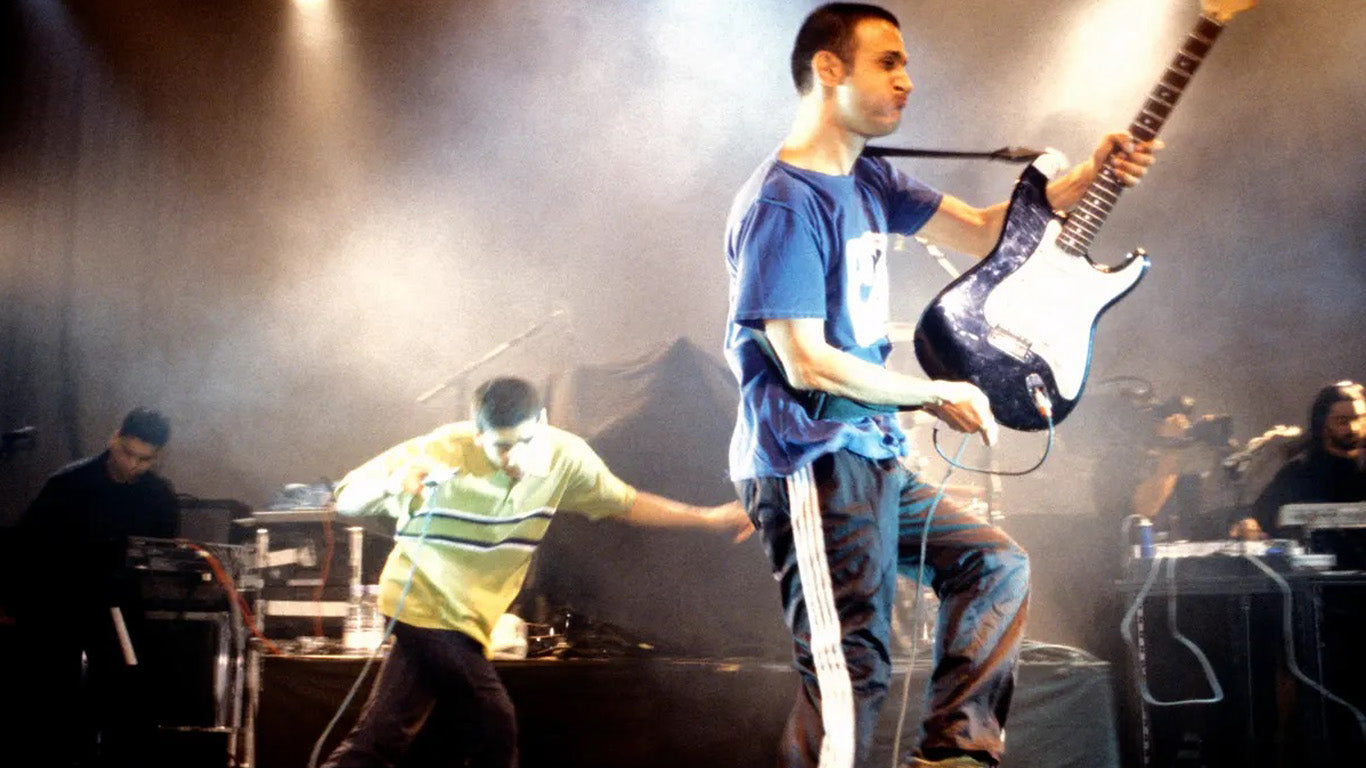 south asian band performing on stage electric guitar