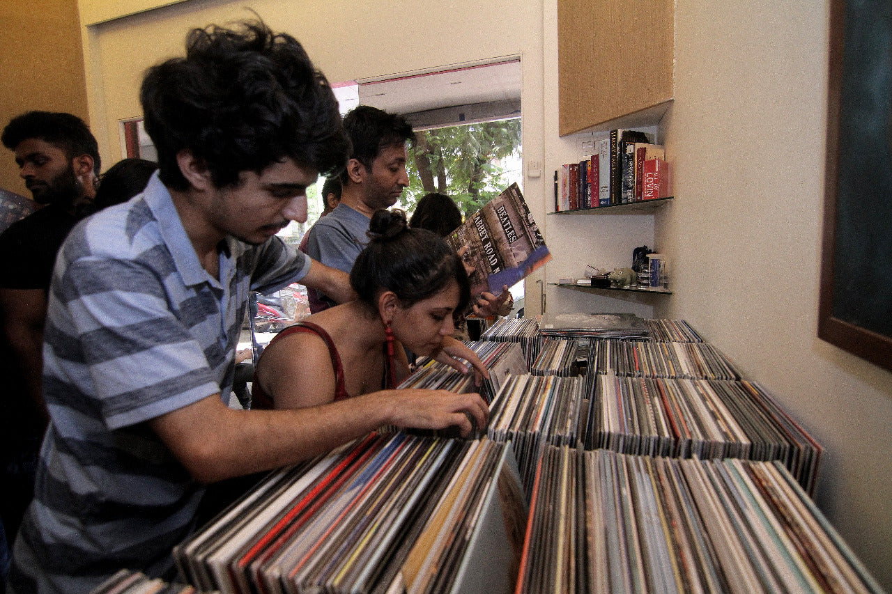People Browsing Through Vinyl Records | The Revolver Cl