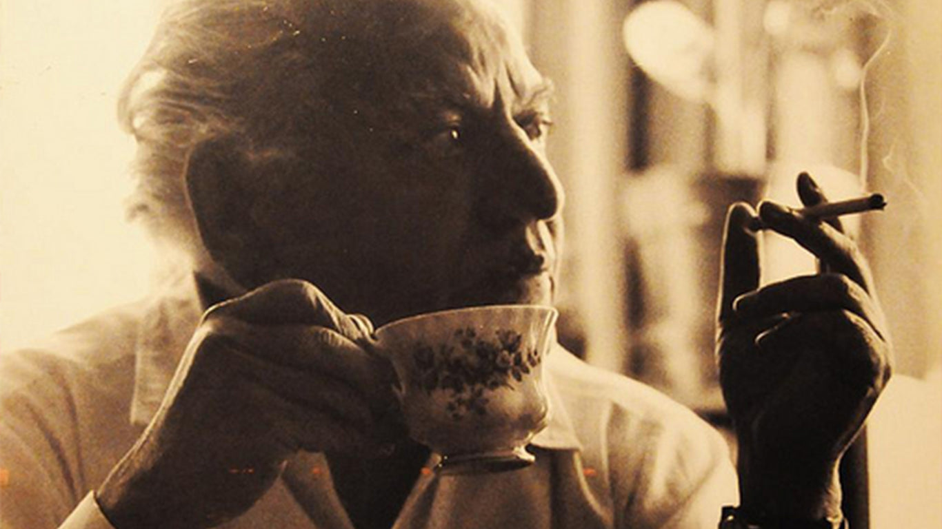 Faiz Ahmed smoking a cigarette and drinking tea