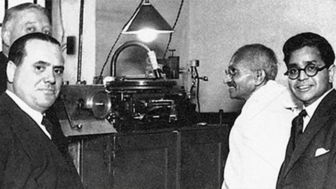 Mahatma Gandhi looking at gramophone