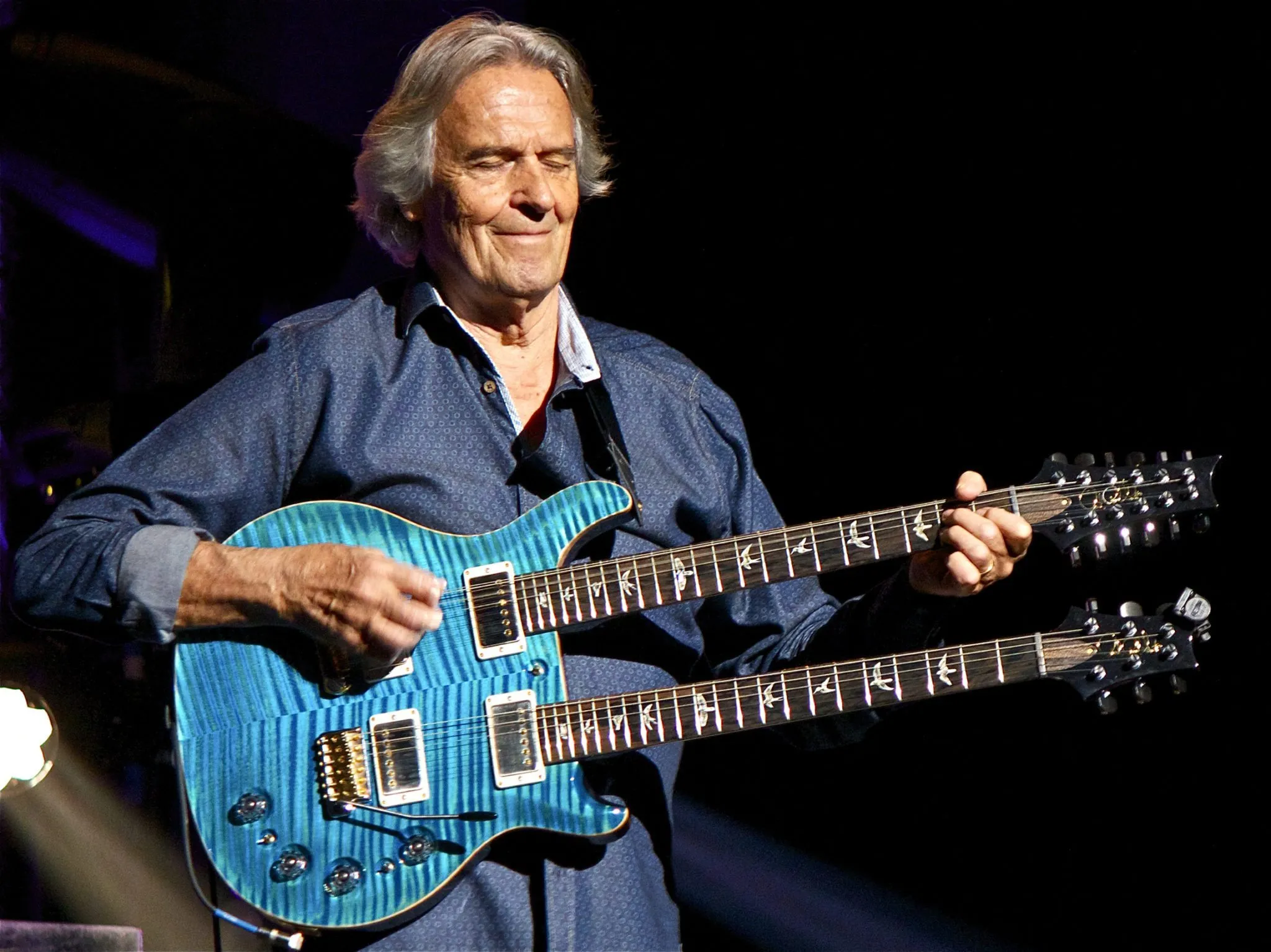 John McLaughlin holding a guitar