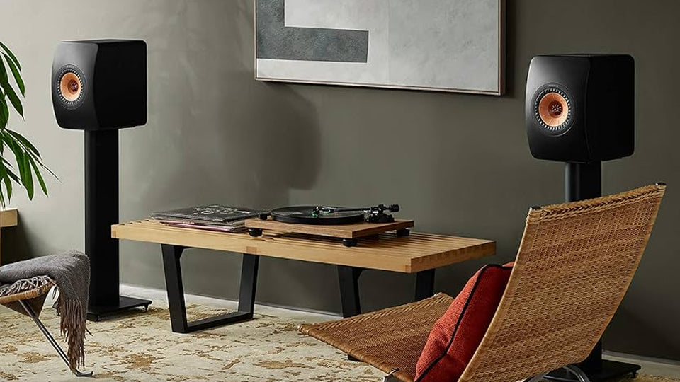 Modern living room with speakers, a bench, and a chair.
